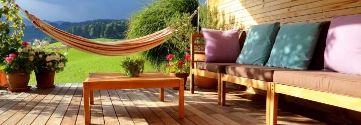 Holzterrasse mit Gartenmöbeln und Hängematte